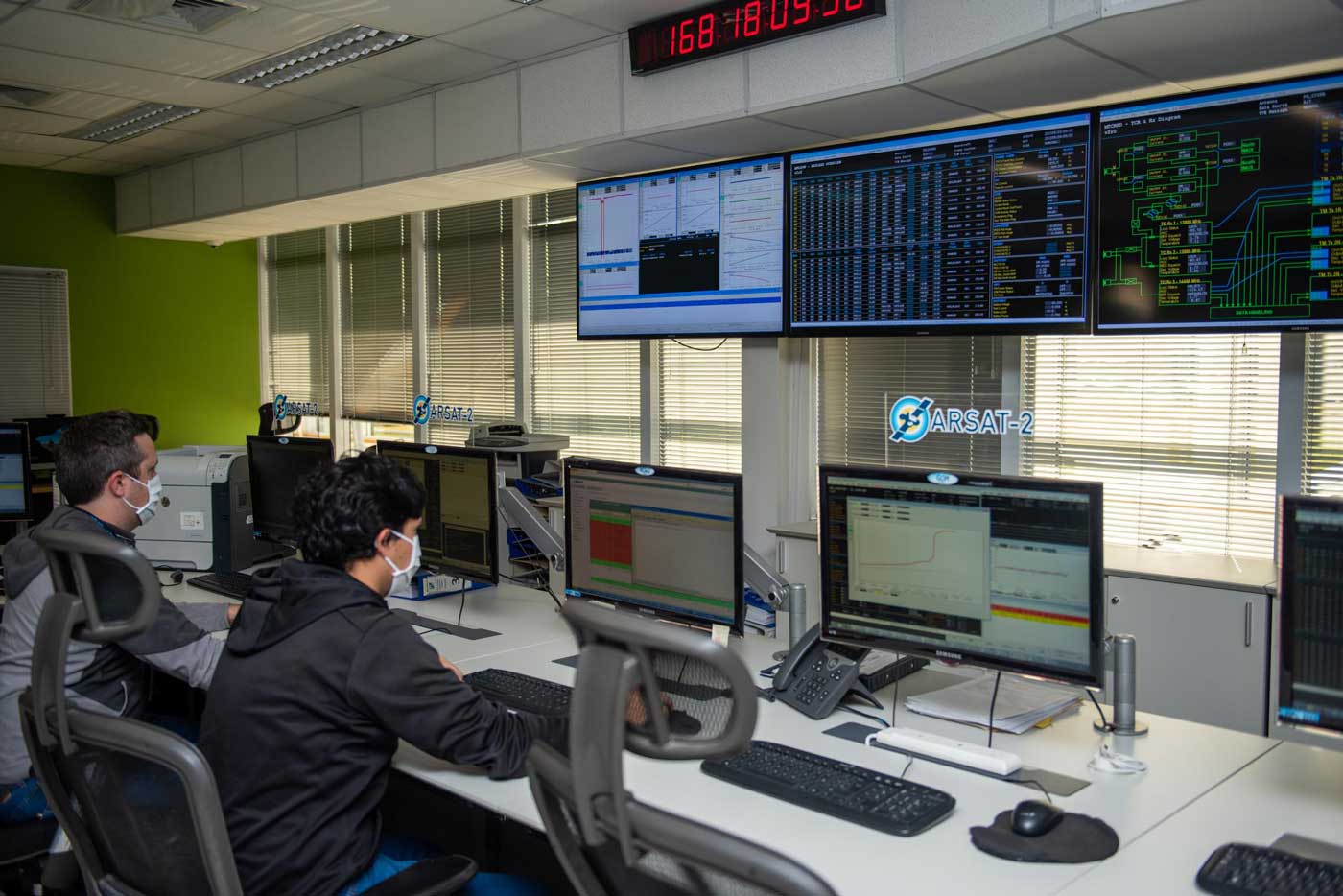 Dos técnicos monitorean y controlan los satélites ARSAT 1 y 2, a través de computadoras en el Centro de Control Satelital.