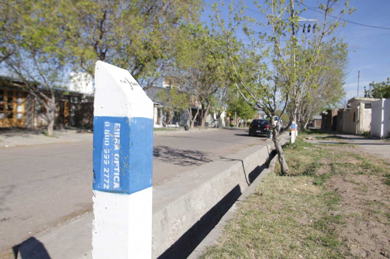 Hilera de monolitos blancos y celestes al borde de una séquia en una localidad mendocina por donde pasa la Red Federal de Fibra Óptica.