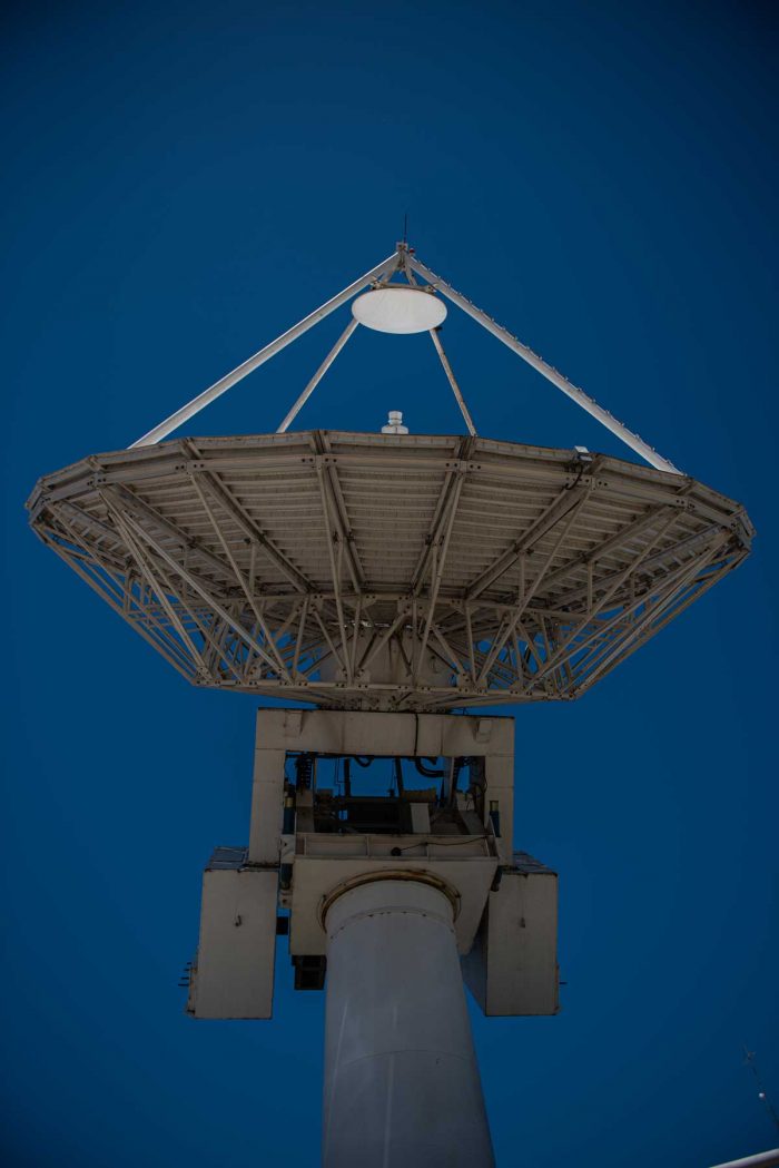 Una gran antena satelital, vista desde abajo, que apunta hacia el cielo donde están el Arsat 1 y 2, para brindar servicio.