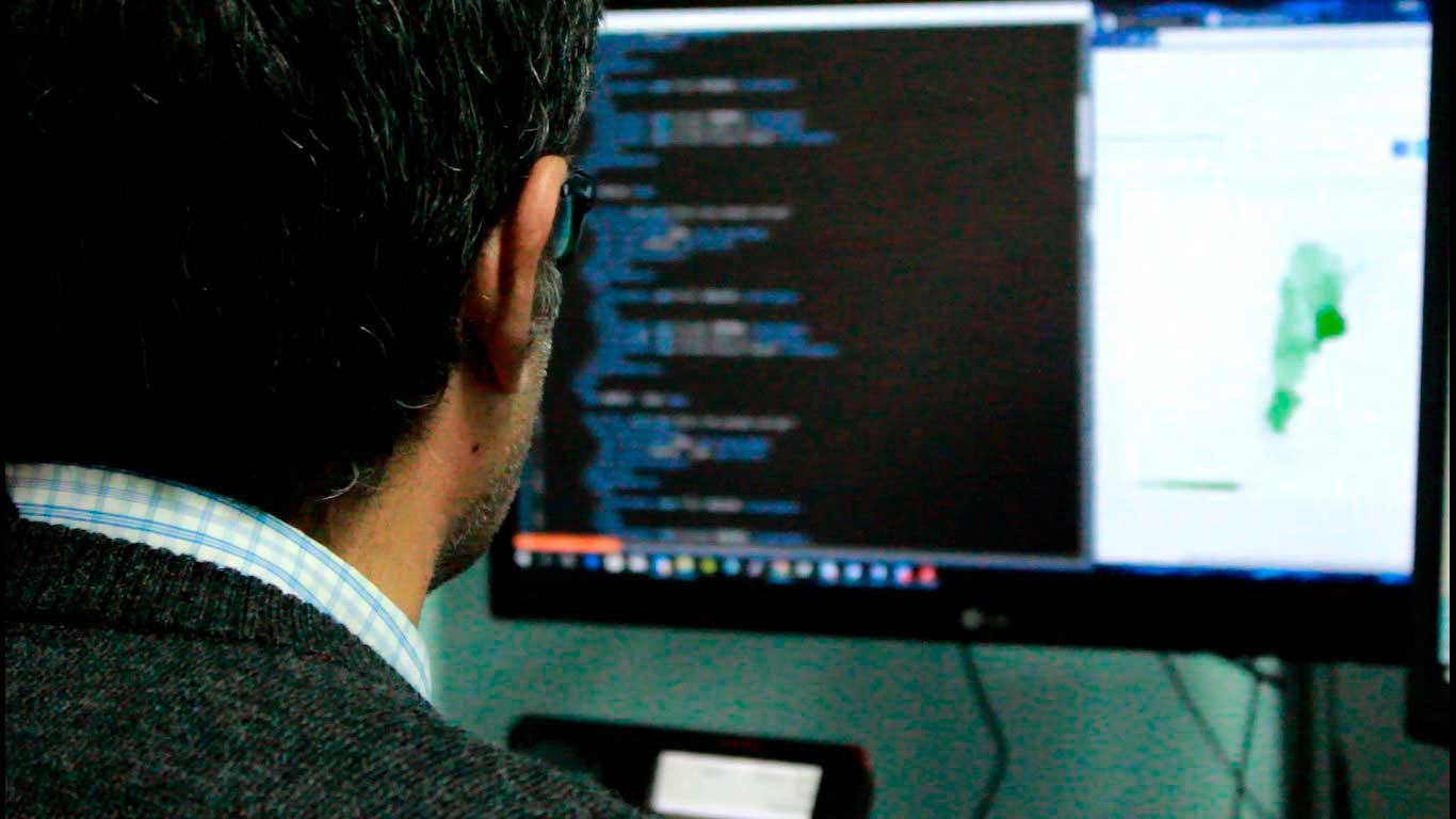 De espalda, un especialista programa en una computadora, sistemas de ciberseguridad.