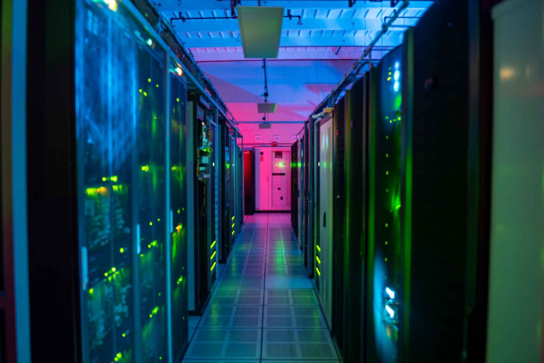 Hileras de racks cerrados e iluminados, en una sala del Centro Nacional de Datos.